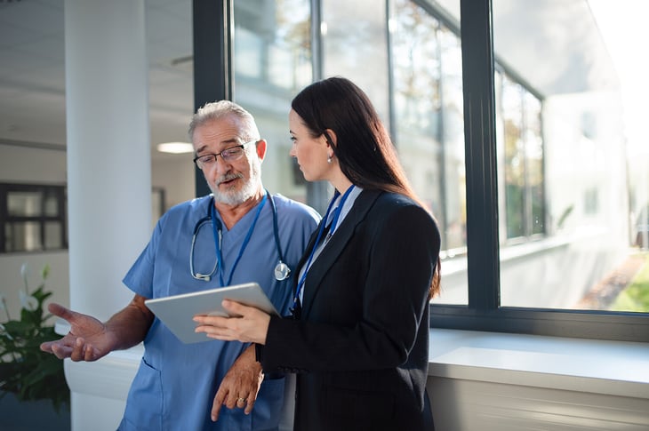 Seller-holding-tablet-explaning-to-doctor-in-hospital-1464782725-1