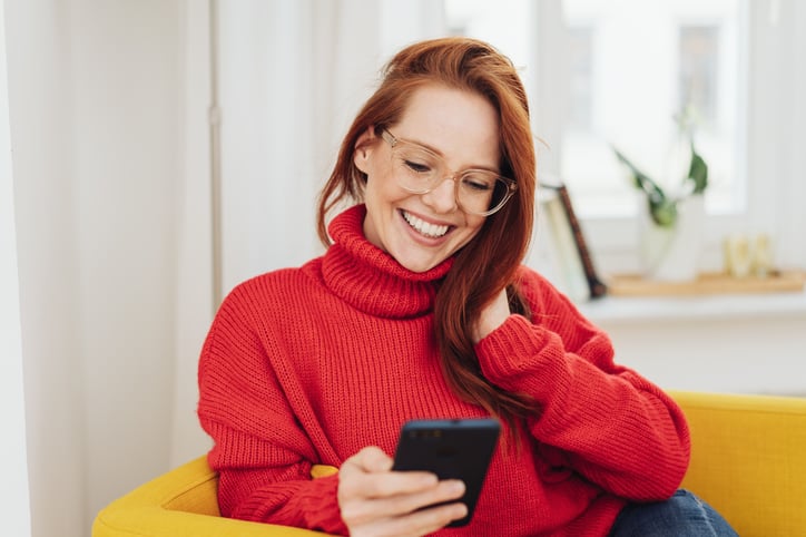 female-european-adult-indoor-looking-at-smartphone-in-her-hand-print